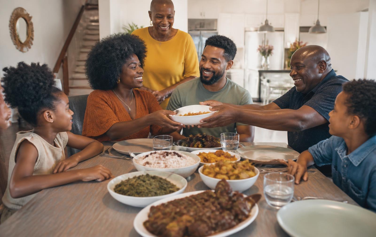 Black family sharing a generous meal prepared by a local home cook